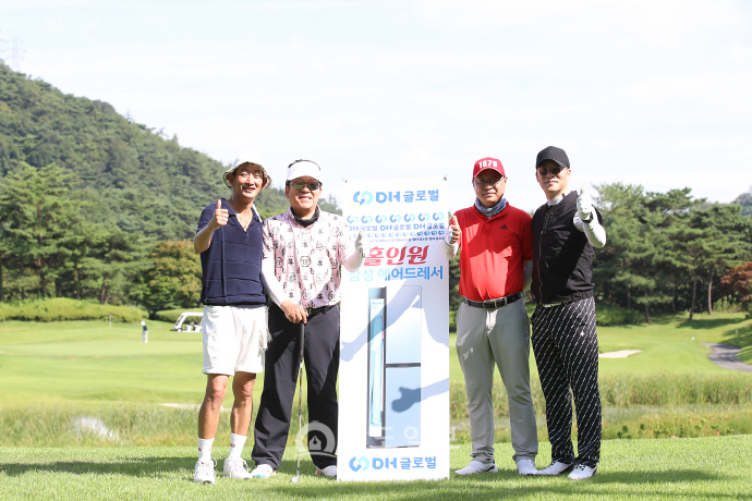 홀인원 상품 앞에서 참가자들이 기념사진을 찍고 있다.