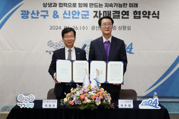 박우량 신안군수(오른쪽)와 박병규 광주 광산구청장이 광산구&신안군 자매결연 협약을 맺고 기념촬영을 하고 있다. /광산구 제공